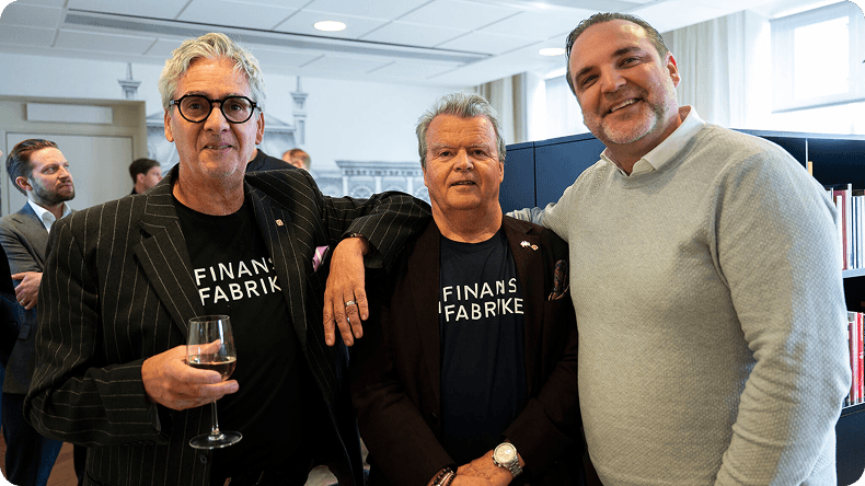 Three men in business casual attire pose smiling at an informal networking event.